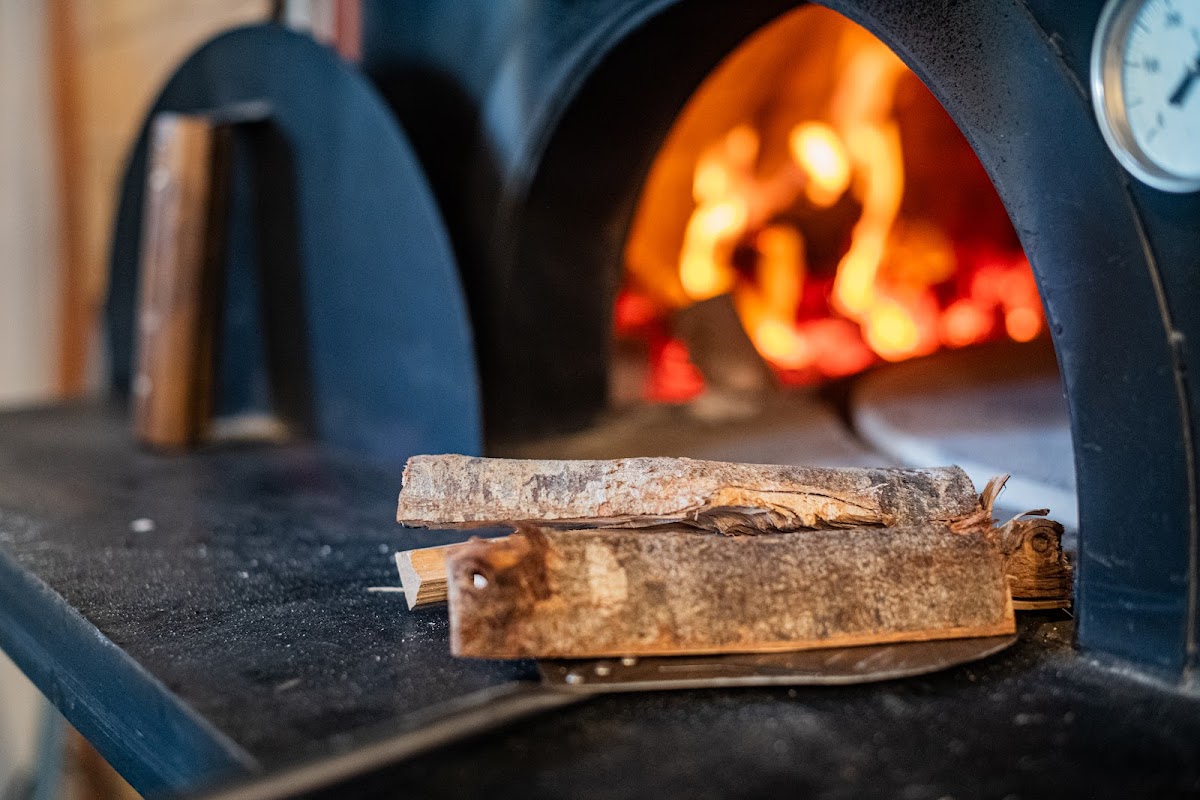 Wood-fired pizza oven with live flames at Pizza Sondrio